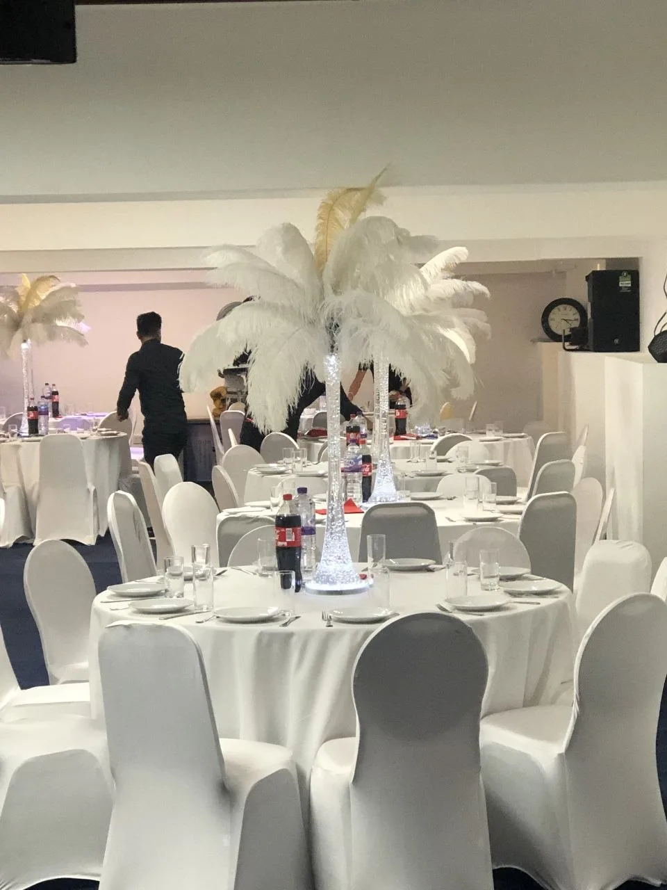 Function room in Erith set with white chair covers and feather centrepieces