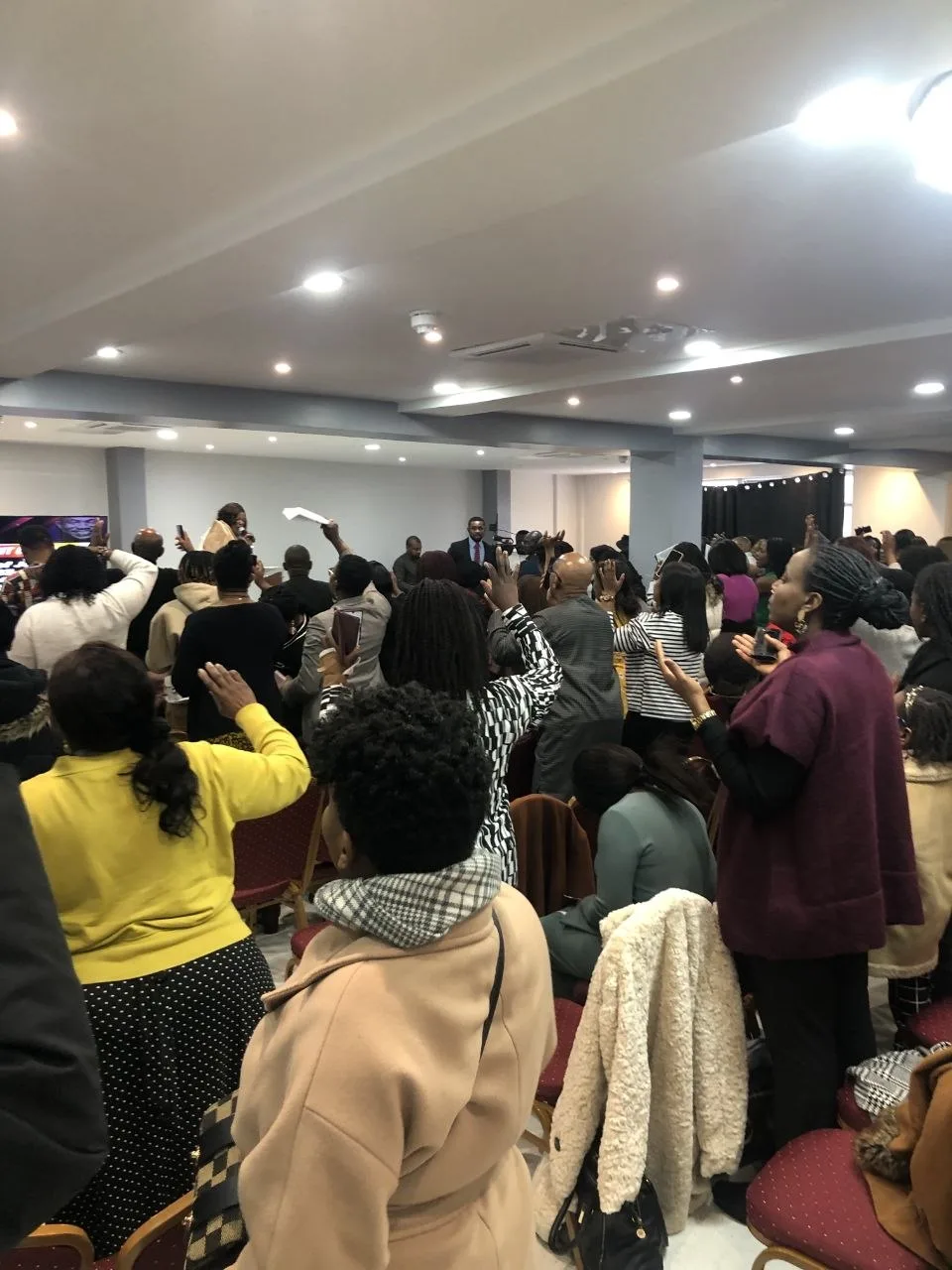 Church service with raised hands in worship at P2 Centre church hall, Erith