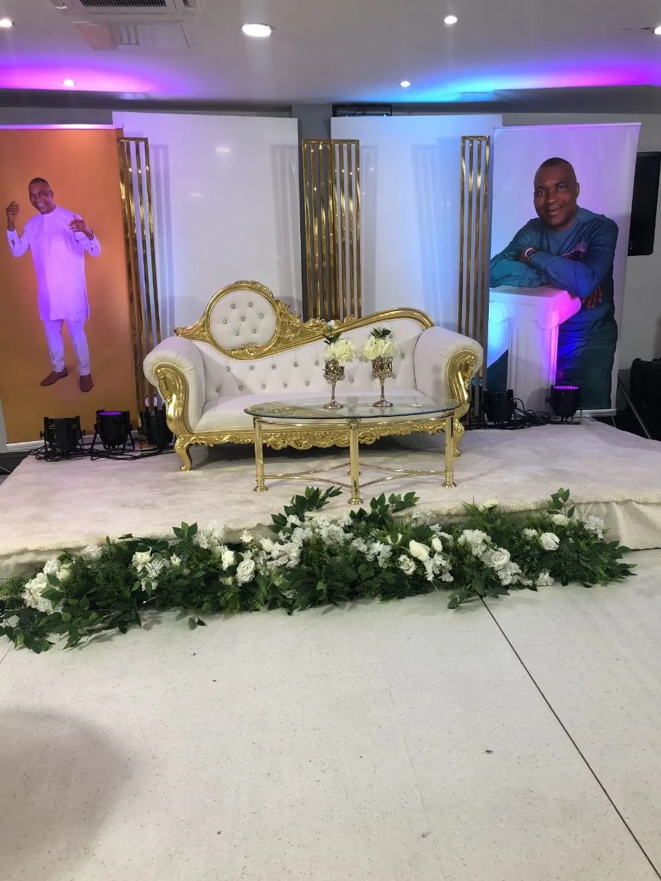 Stage with white and gold sofa, gold panels and a floral garland at P2 Centre, Erith
