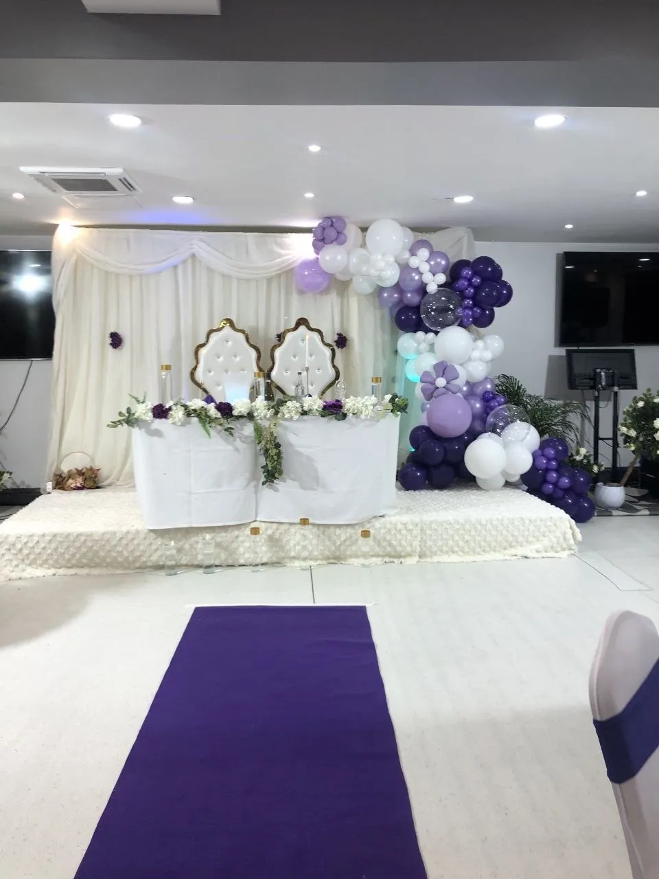 Top table with two white and gold chairs and a purple balloon arch at P2 Centre, Erith