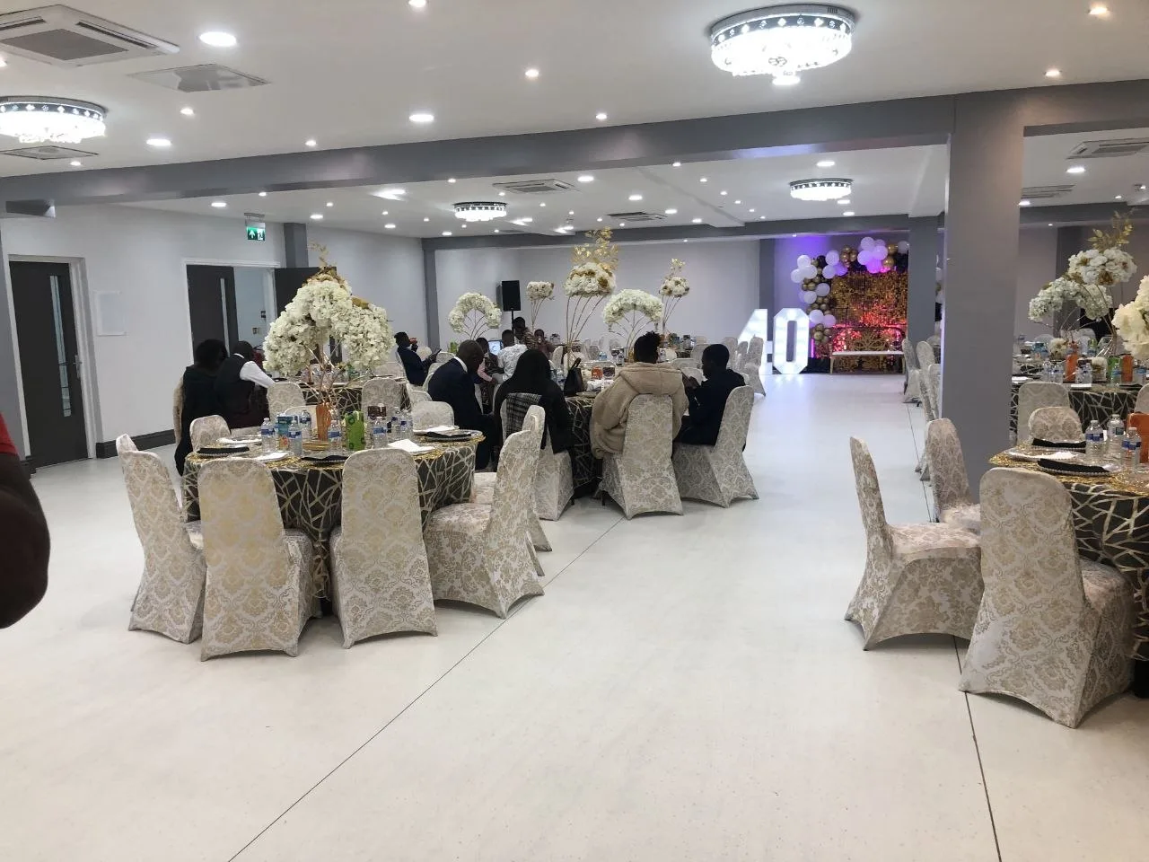 40th birthday party in the main event hall at P2 Centre, Erith, with damask chair covers and floral centrepieces