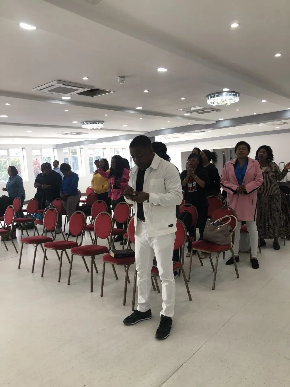 Worshippers praying during a church service in the P2 Centre hall, Erith